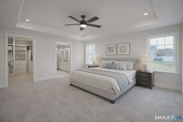 a spacious bedroom with a large bed and a chandelier
