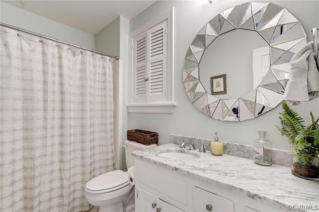 3421 Kenmore Road Richmond, VA 23225 - Photo 19 of 41 a bathroom with a granite countertop sink mirror vanity and toilet
