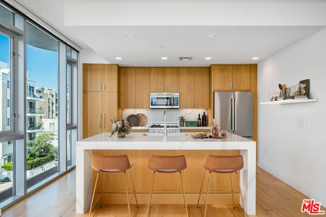 a kitchen with stainless steel appliances granite countertop a sink a stove and a refrigerator