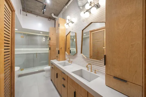a spacious bathroom with a double vanity sink a mirror and shower