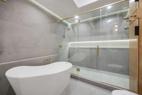 a bathroom with a white bath tub and a shower