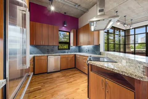 a kitchen with granite countertop a sink window and cabinets