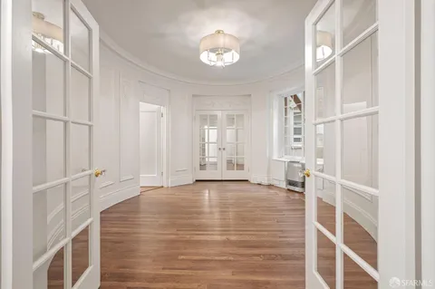 an empty room with wooden floor and window