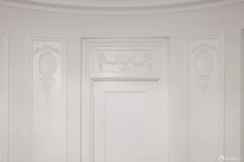 a view of a room with wooden floor mirror and a bathroom