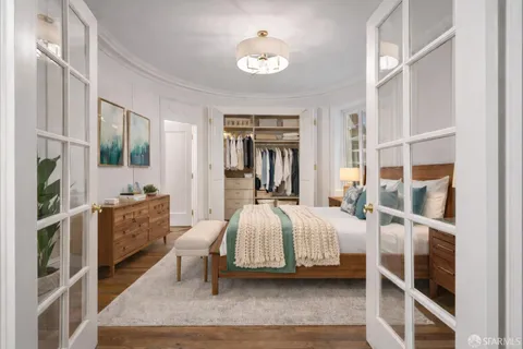 a bedroom with a bed and a large window