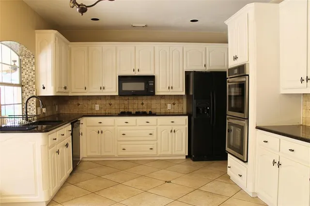 a kitchen with white cabinets and stainless steel appliances
