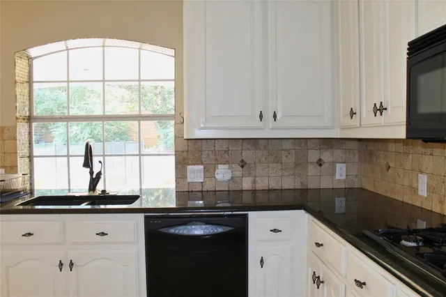 a kitchen with a white cabinets and a refrigerator