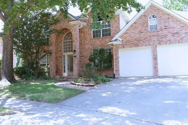a front view of a house with yard and trees