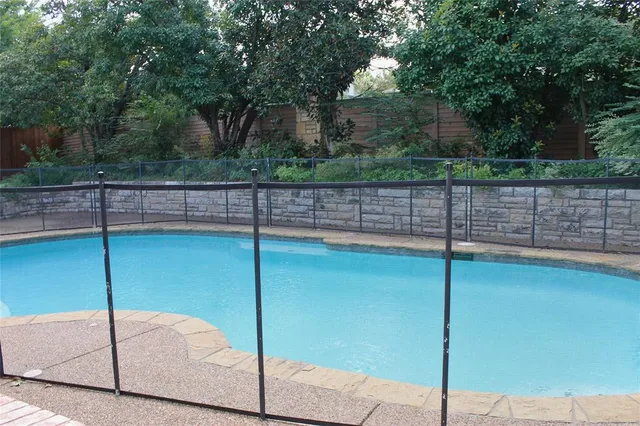 a view of a backyard and swimming pool
