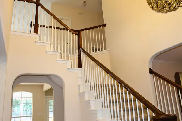 a view of staircase with railing and a window