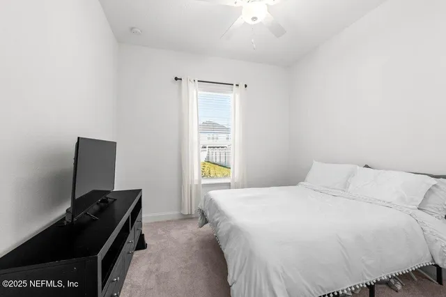 a bedroom with a chair and a window