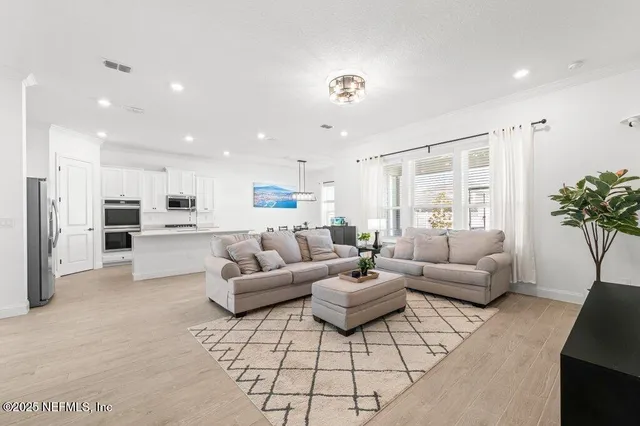 a living room with furniture a flat screen tv and a window