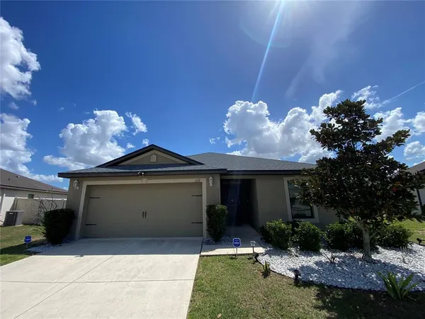 a front view of a house with a yard and garage