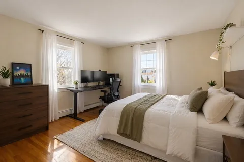 a bedroom with a bed and wooden floor