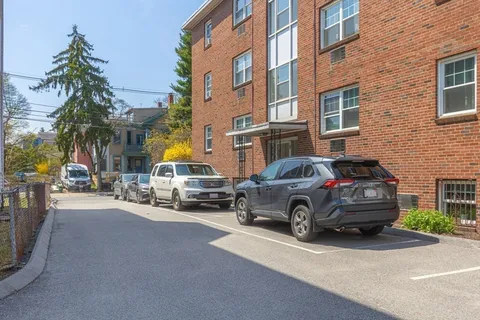 a car parked in front of a brick house