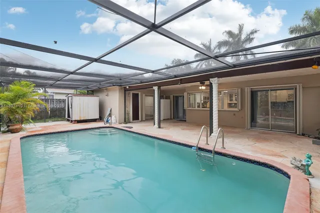 a view of a house with pool and chairs