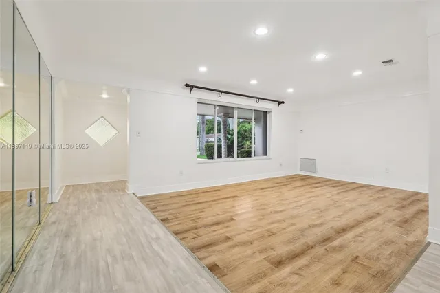 a view of empty room with wooden floor