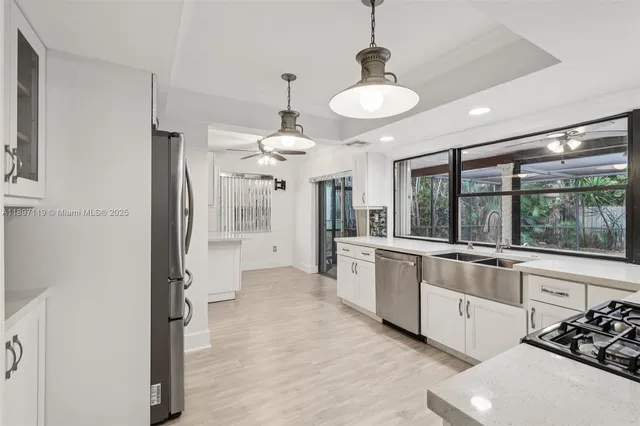 a large kitchen with a large window and stainless steel appliances