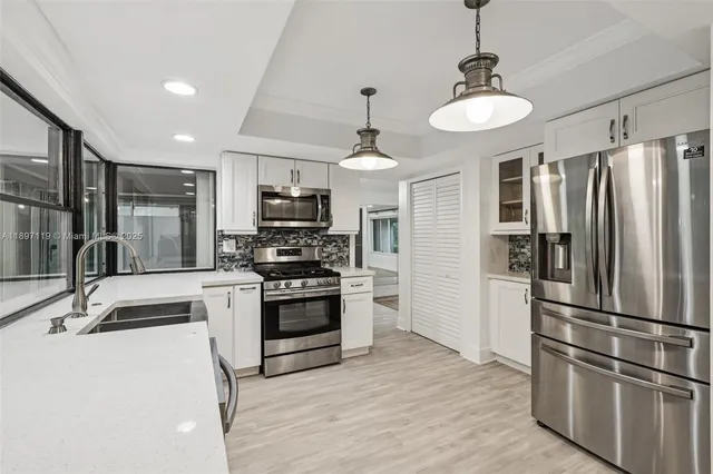 a large kitchen with cabinets and stainless steel appliances