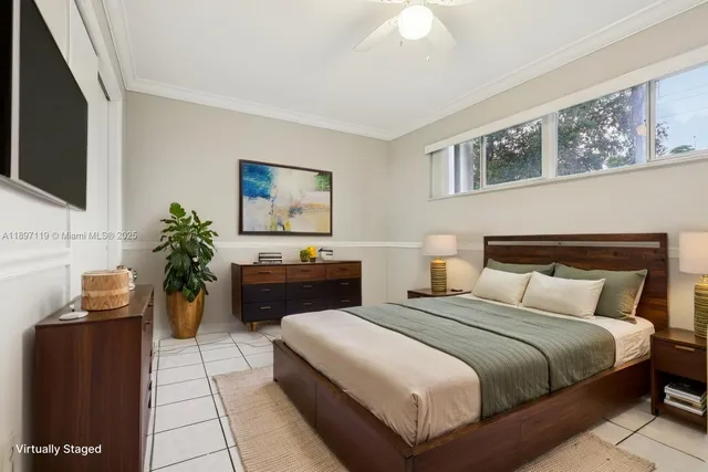 a bedroom with a large bed and a flat tv screen on dresser
