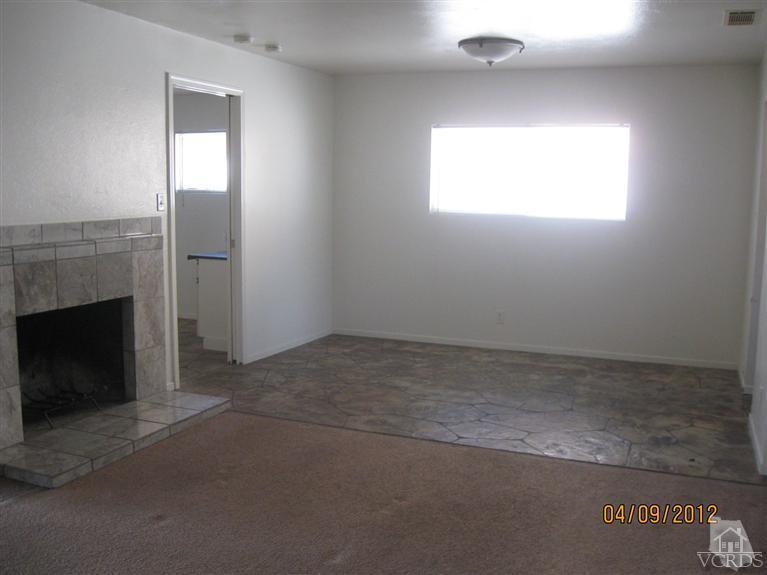 1408 West Guava Street Oxnard, CA 93033 - Photo 3 of 9 an empty room with a fireplace and windows