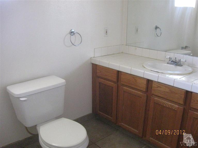 1408 West Guava Street Oxnard, CA 93033 - Photo 7 of 9 a bathroom with a granite countertop toilet and a sink