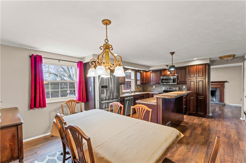 191 Deer Drive Washington, PA 15301 - Photo 14 of 33 a kitchen with stainless steel appliances kitchen island granite countertop a refrigerator a stove a sink dishwasher a dining table and chairs with wooden floor