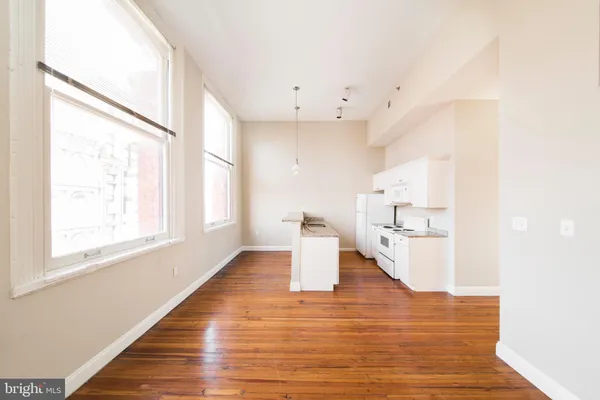 a kitchen with stainless steel appliances granite countertop a stove a sink dishwasher and a refrigerator with wooden floor