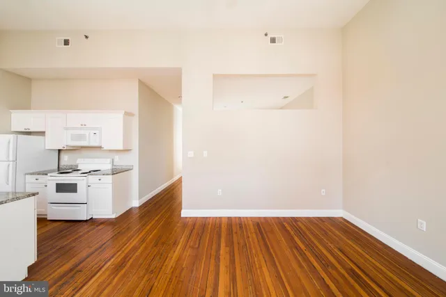 a view of kitchen with wooden floor and electronic appliances