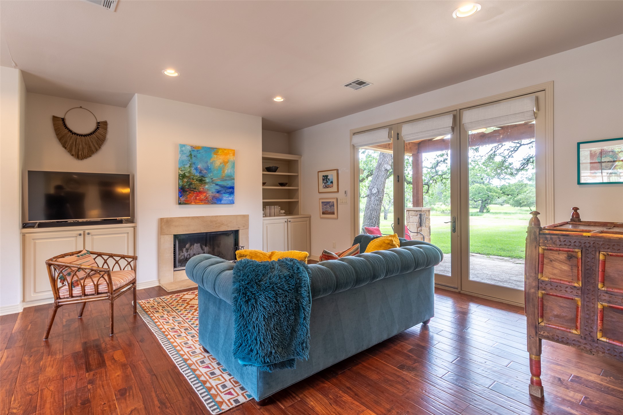 515 E Trail Spicewood, TX 78669 - Photo 18 of 36 a living room with furniture a flat screen tv and a fireplace
