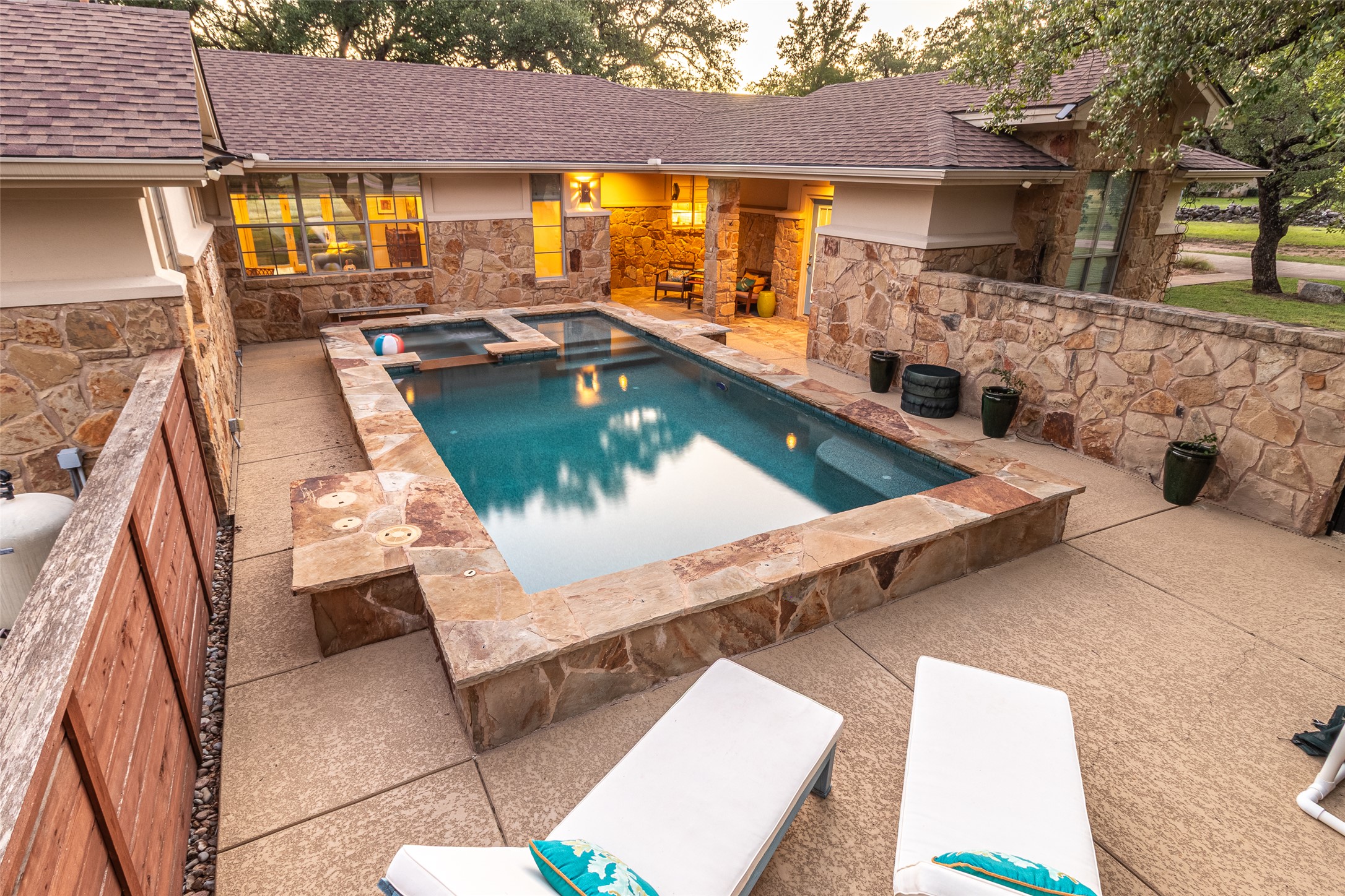 515 E Trail Spicewood, TX 78669 - Photo 30 of 36 a view of a patio with couches table and chairs under an umbrella