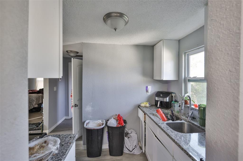 1208 17th Street North St. Petersburg, FL 33713 - Photo 7 of 15 a bathroom with a granite countertop sink a toilet and a shower