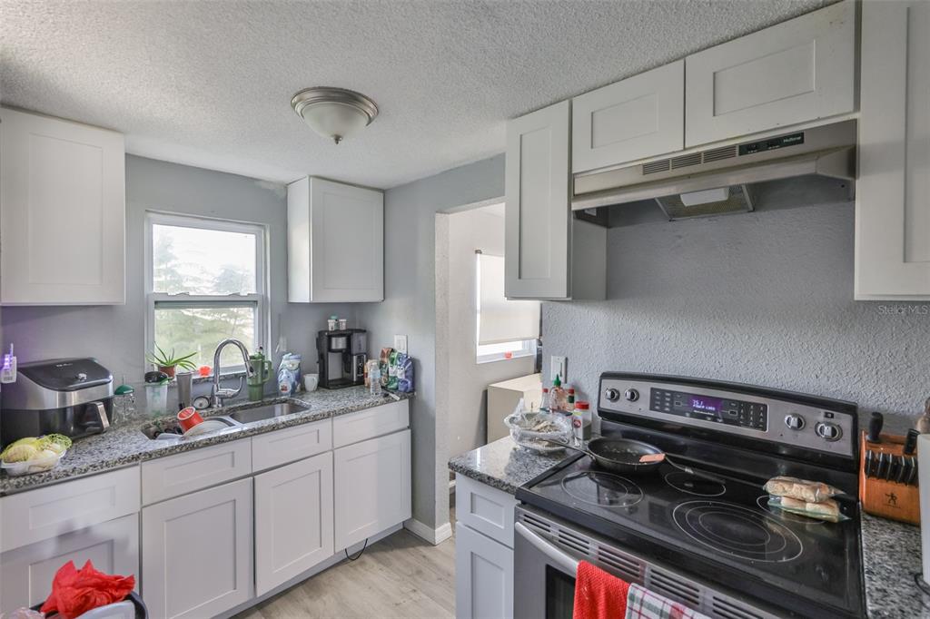 1208 17th Street North St. Petersburg, FL 33713 - Photo 8 of 15 a kitchen with stainless steel appliances granite countertop a stove and a sink
