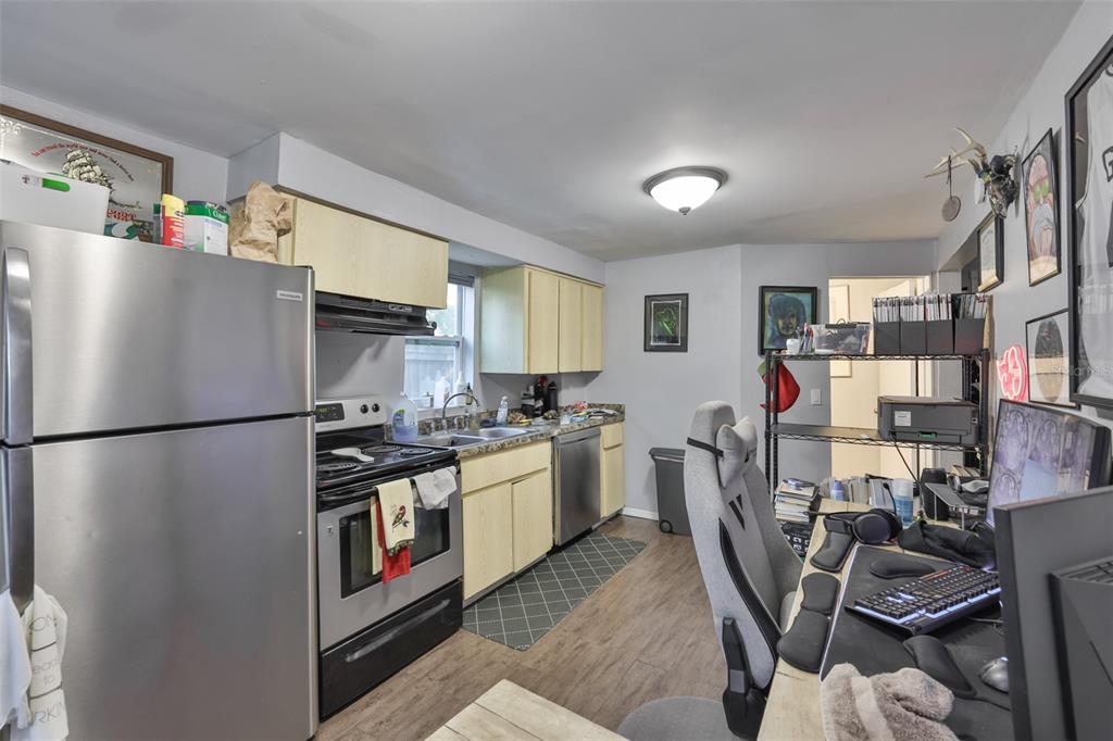 1208 17th Street North St. Petersburg, FL 33713 - Photo 9 of 15 a kitchen with stainless steel appliances a refrigerator a sink a stove and white cabinets