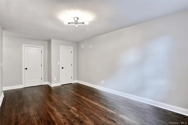 a view of wooden floor and a chandelier fan in a room