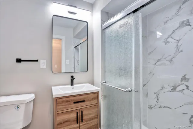 a bathroom with a toilet a sink and mirror