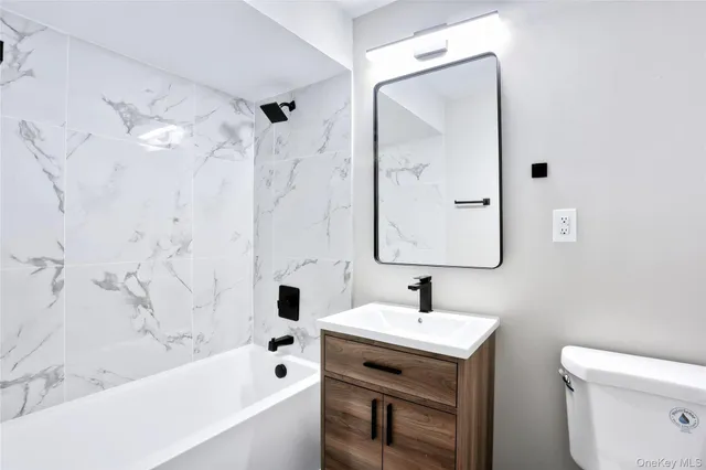 a bathroom with a sink mirror toilet and bathtub