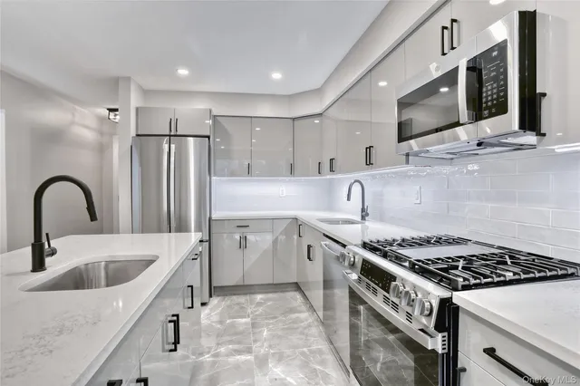 a kitchen with stainless steel appliances granite countertop a sink stove and refrigerator