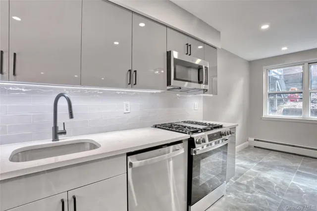 a kitchen with stainless steel appliances granite countertop a sink stove and cabinets