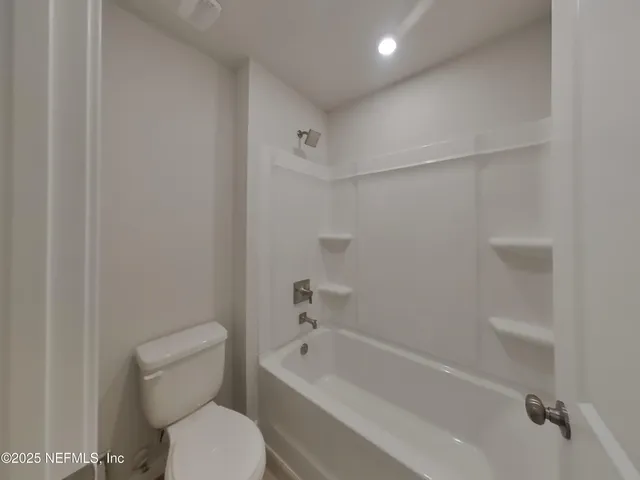 a bathroom with a toilet and a tub