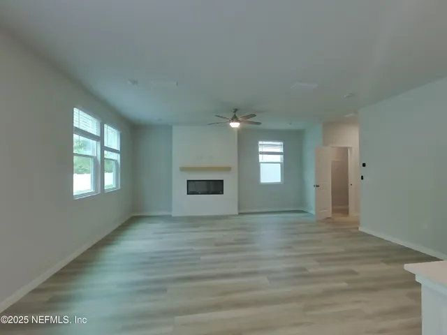a view of an empty room with a window and fireplace
