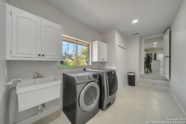 a utility room with sink dryer and washer