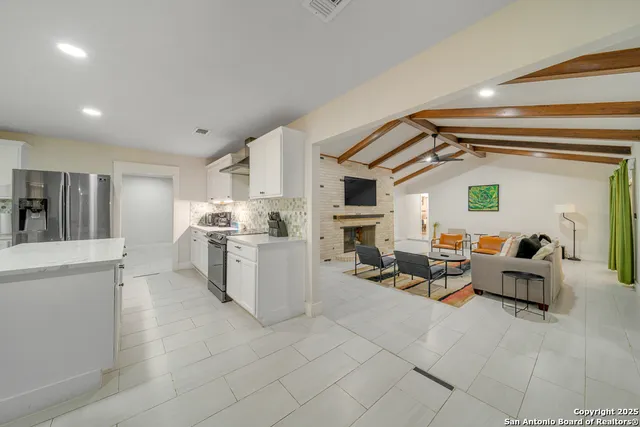 a kitchen that has a lot of white cabinets and couches