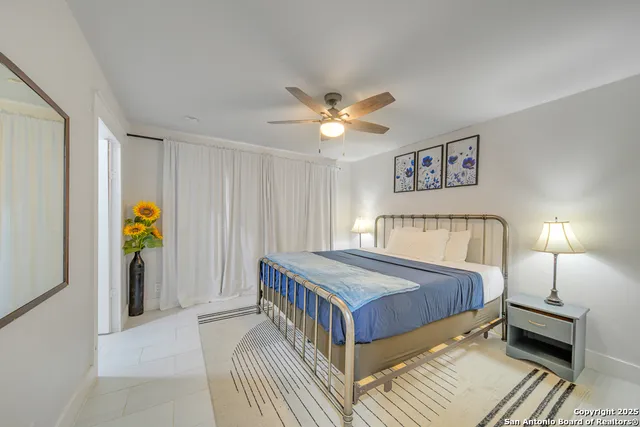 a bedroom with a bed and a ceiling fan