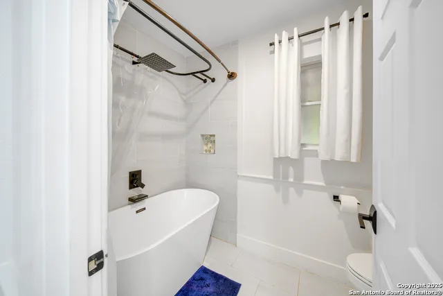 a spacious bathroom with a granite countertop sink and a mirror