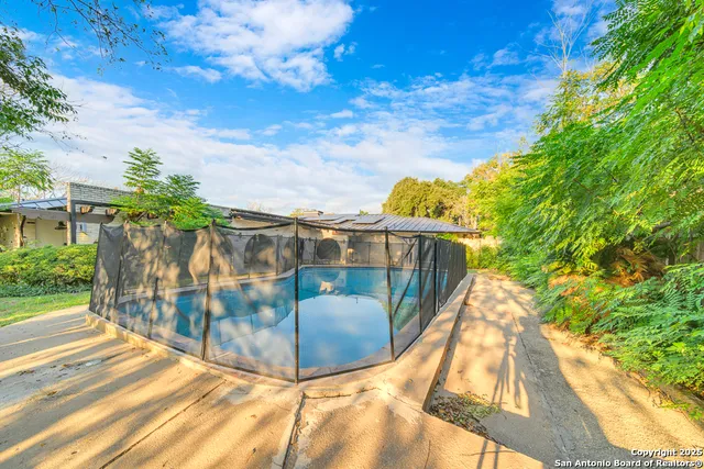 a view of a street with a house in the background