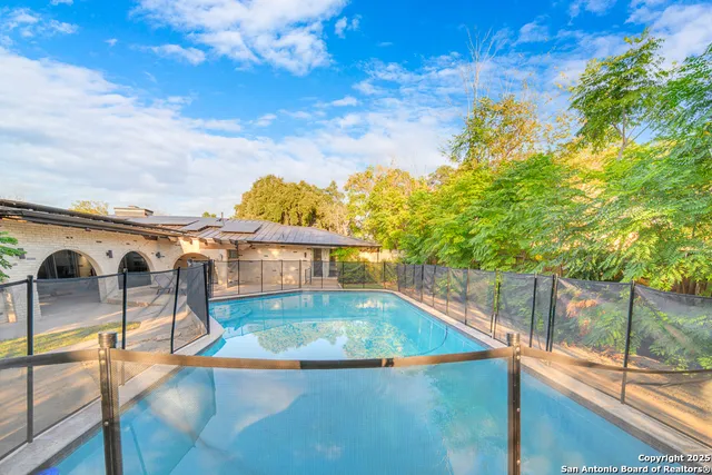 a view of a house with a yard and palm trees