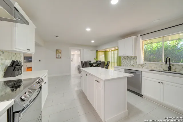 a kitchen with sink a white cabinets and appliances