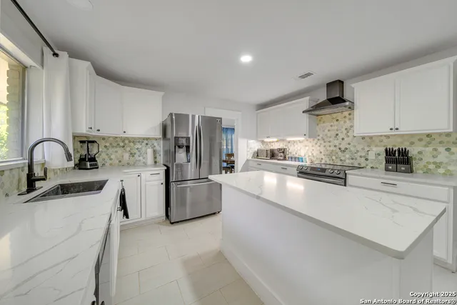 a kitchen with refrigerator and cabinets