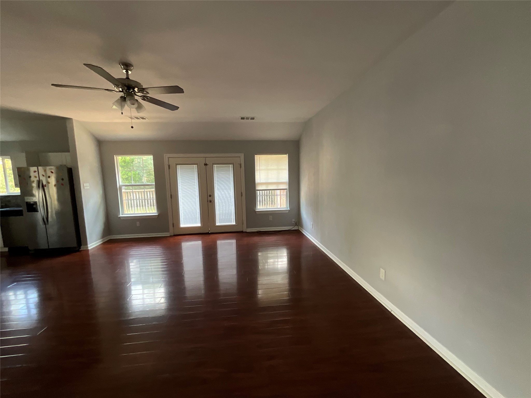 239 Old Firetower Road Bastrop, TX 78602 - Photo 19 of 39 Unfurnished living room with french doors, healthy amount of natural light, and dark wood-type flooring